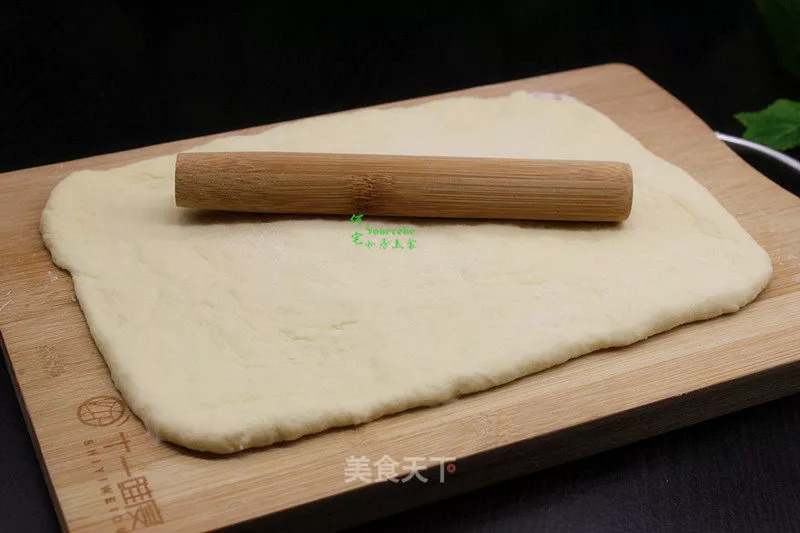 5 中间发酵好的面团在案板上撒点面粉,擀成长方形面片