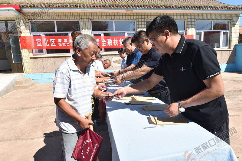 8月30日,宣化区庞家堡镇,工作人员为贫困户发放公益岗位"薪酬.