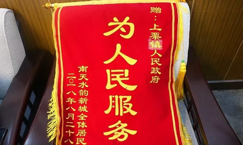 南天水韵新城小区居民为上栗镇送来了"为人民服务"的锦旗,居民代表龚