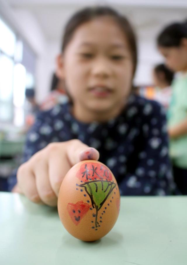 苏州市平江实验学校学生"秋分"时节做"竖蛋"游戏