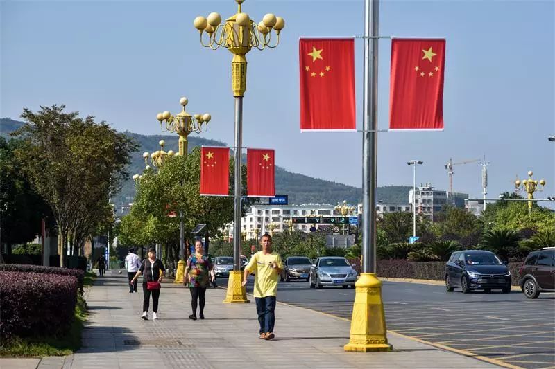 我县街头,广场节日氛围浓 鲜花,国旗喜迎国庆