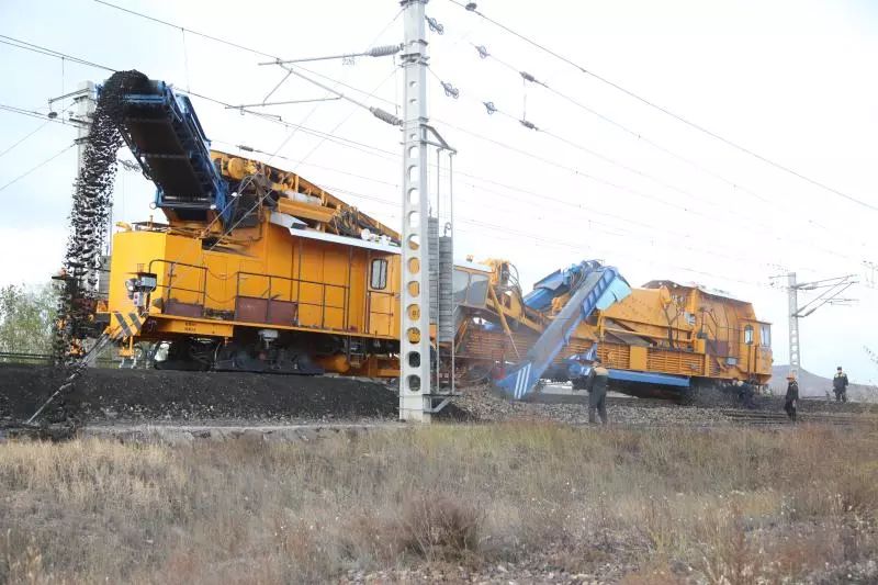 清篩機旋轉輸送帶將汙土拋出完美弧線,配砟車,搗固車,穩定車緊隨其後.