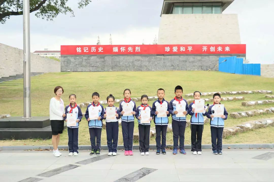 宝山区泗东小学校长林燕老师为参加升旗仪式的同学颁发纪念证书.