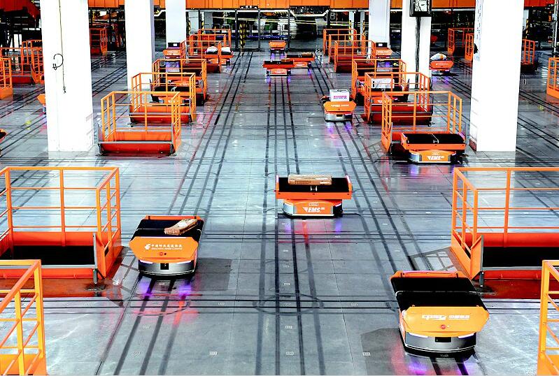 图为:一台台橙色的机器人有序地进行快递包裹的分拣工作