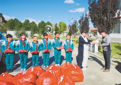 图为湖北省爱心人士黄益生(右二)给曲松镇小学师生送去慰问品.