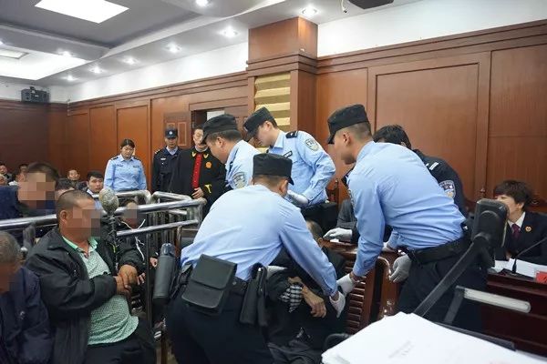 法警將被告人抬入被告席庭審結束後,其中在押的7名被告人被押解至