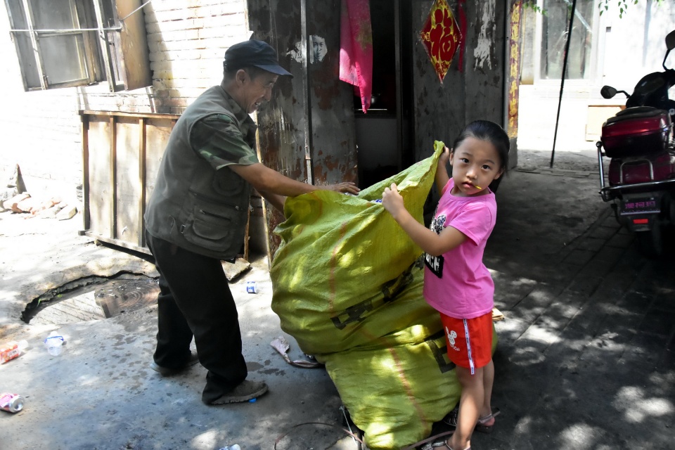 幼儿园小女孩拖着大袋子捡垃圾,路人感叹,好孩子咋都在别人家呢