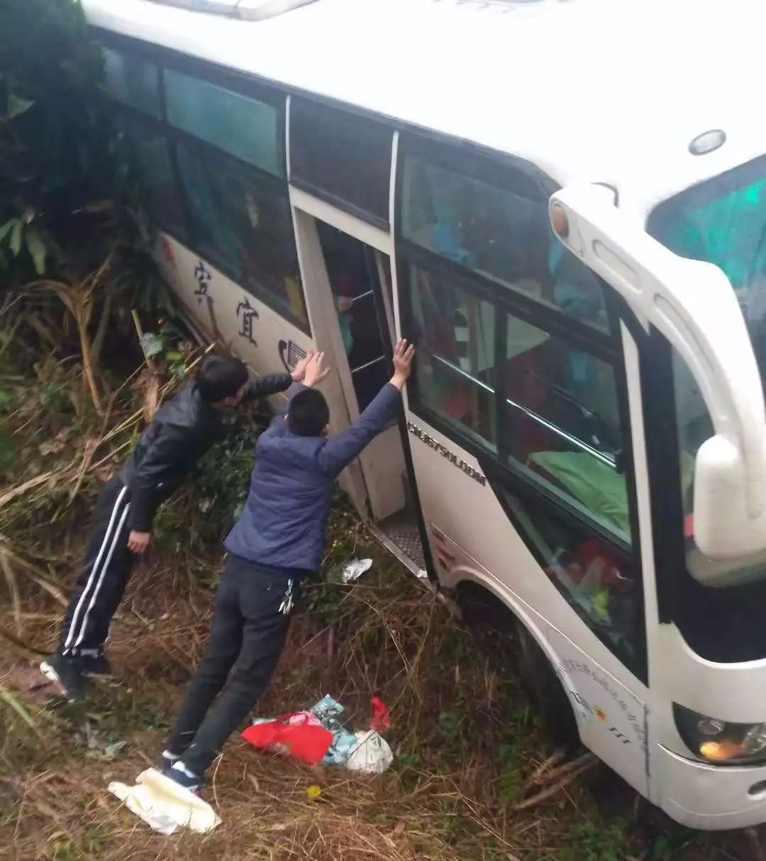 ▼侧翻的客车,众人吊住客车防止下翻由于客车里面有乘客没有及时下来