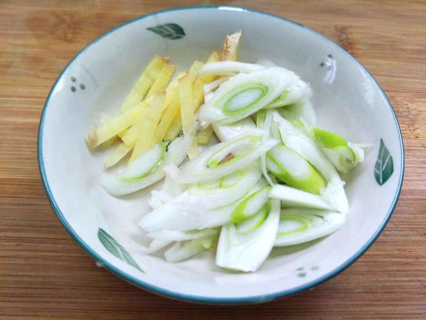 5,起锅加菜籽油,炒香姜丝葱碎,加入口蘑片翻炒变软.