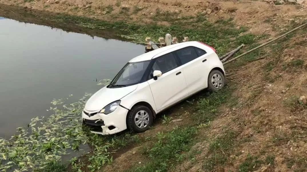 而衝下魚塘的名爵小車車頭陷入水中,駕駛座車門緊閉.