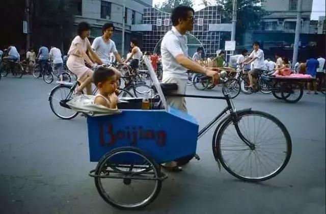 80年代北京街頭,孩子坐在父親改裝的自行車上