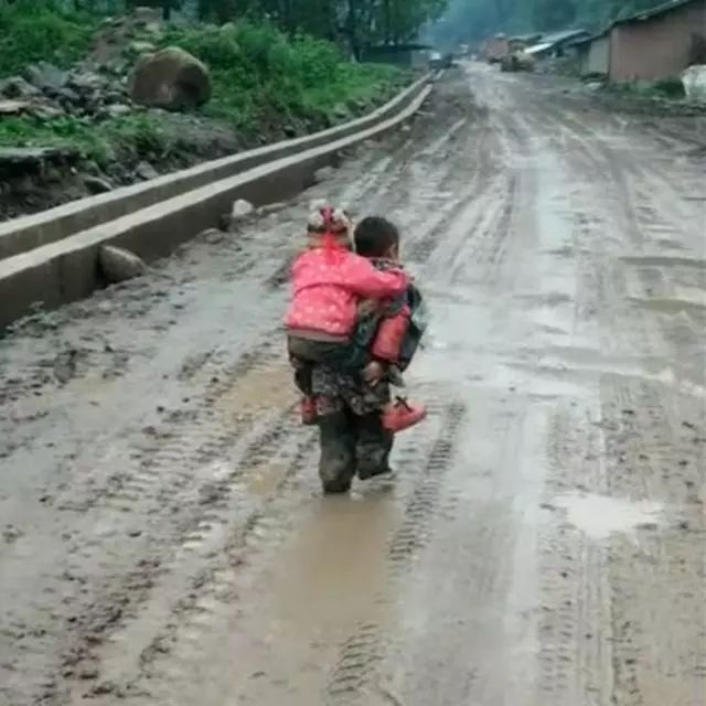 冷冷的下雨天泥泞山路上哥哥背着妹妹上学网友愿你三冬暖