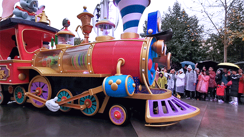 欢快的音乐载着米奇和迪士尼朋友的七彩小火车慢慢开来跟上巡游花车