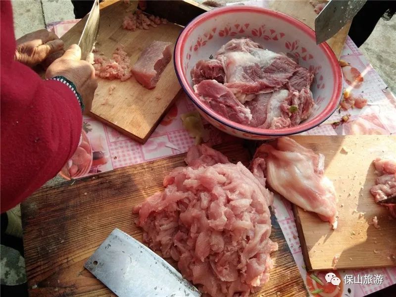 一块块温热的猪肉送到了案板上,菜花腌菜拌生肉是保山年猪饭里一道