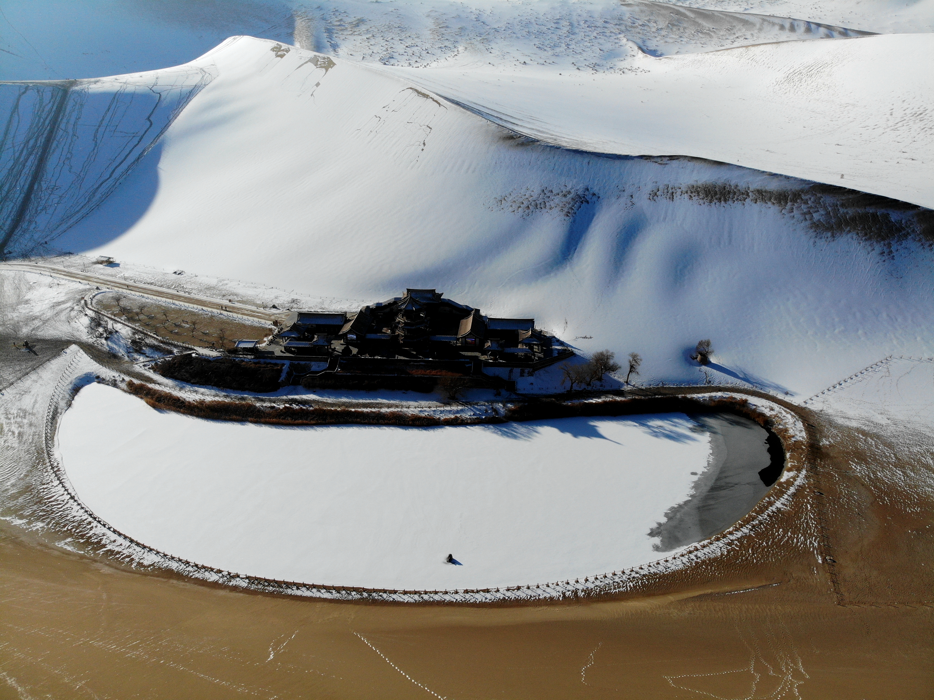 这是1月21日无人机拍摄的甘肃省敦煌市鸣沙山月牙泉景区雪景