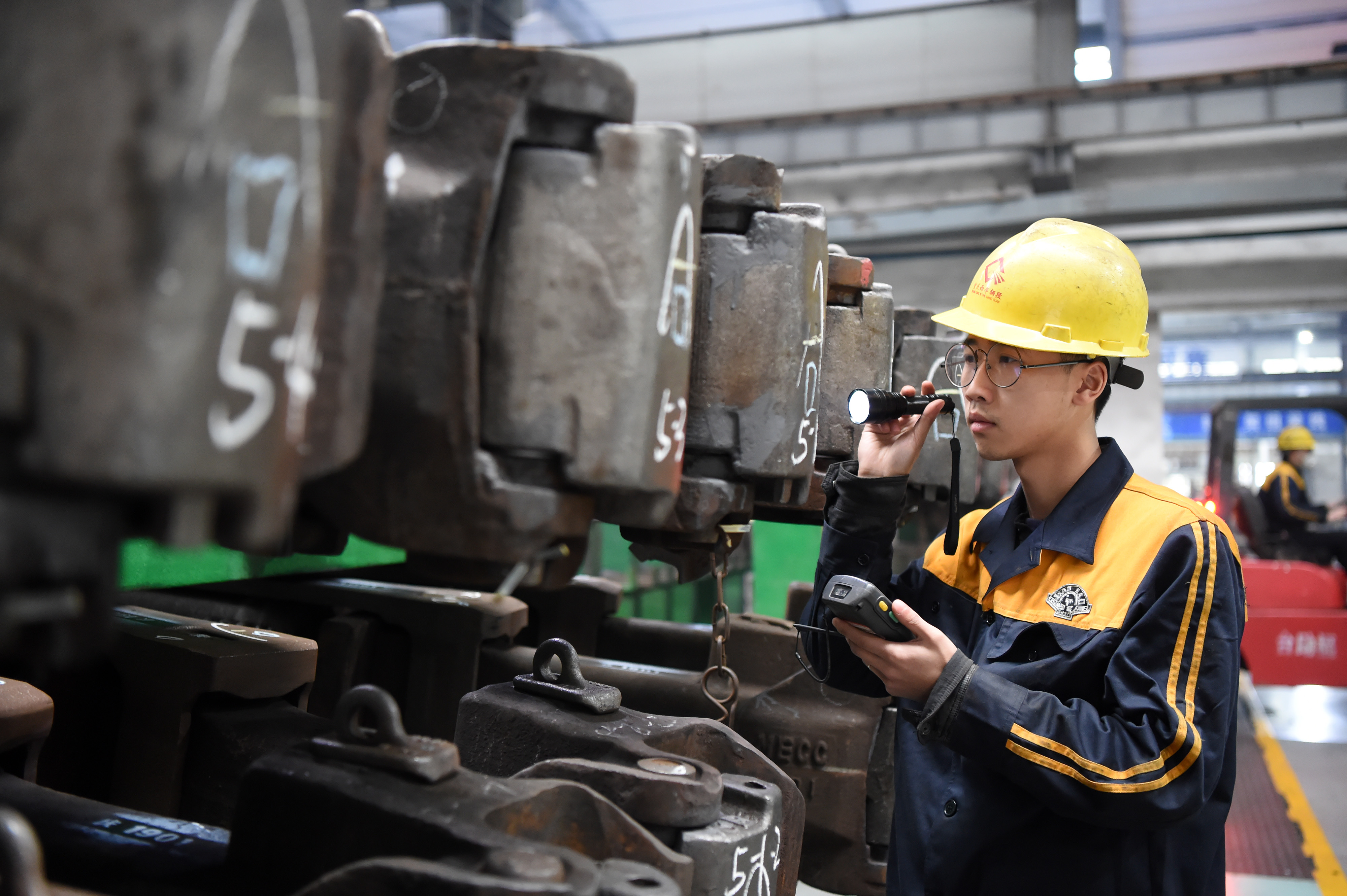 1月25日,重庆西车辆段职工在检查货运列车车钩缓冲装置