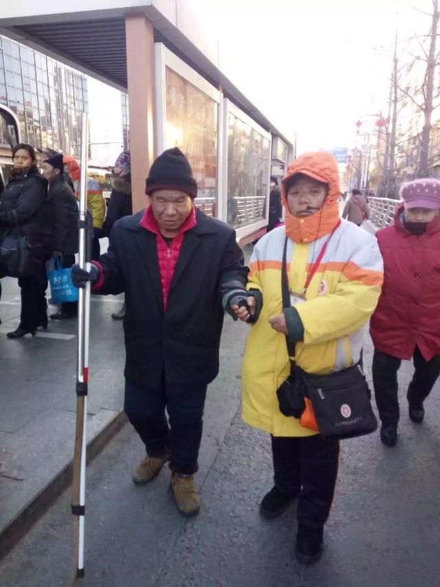 位盲人过马路困难,她主动上前搀扶肓人过马路,引导员关姝又扶他上了车