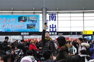 2019年2月1日,北京南站,一位男士在候車廳拍照.