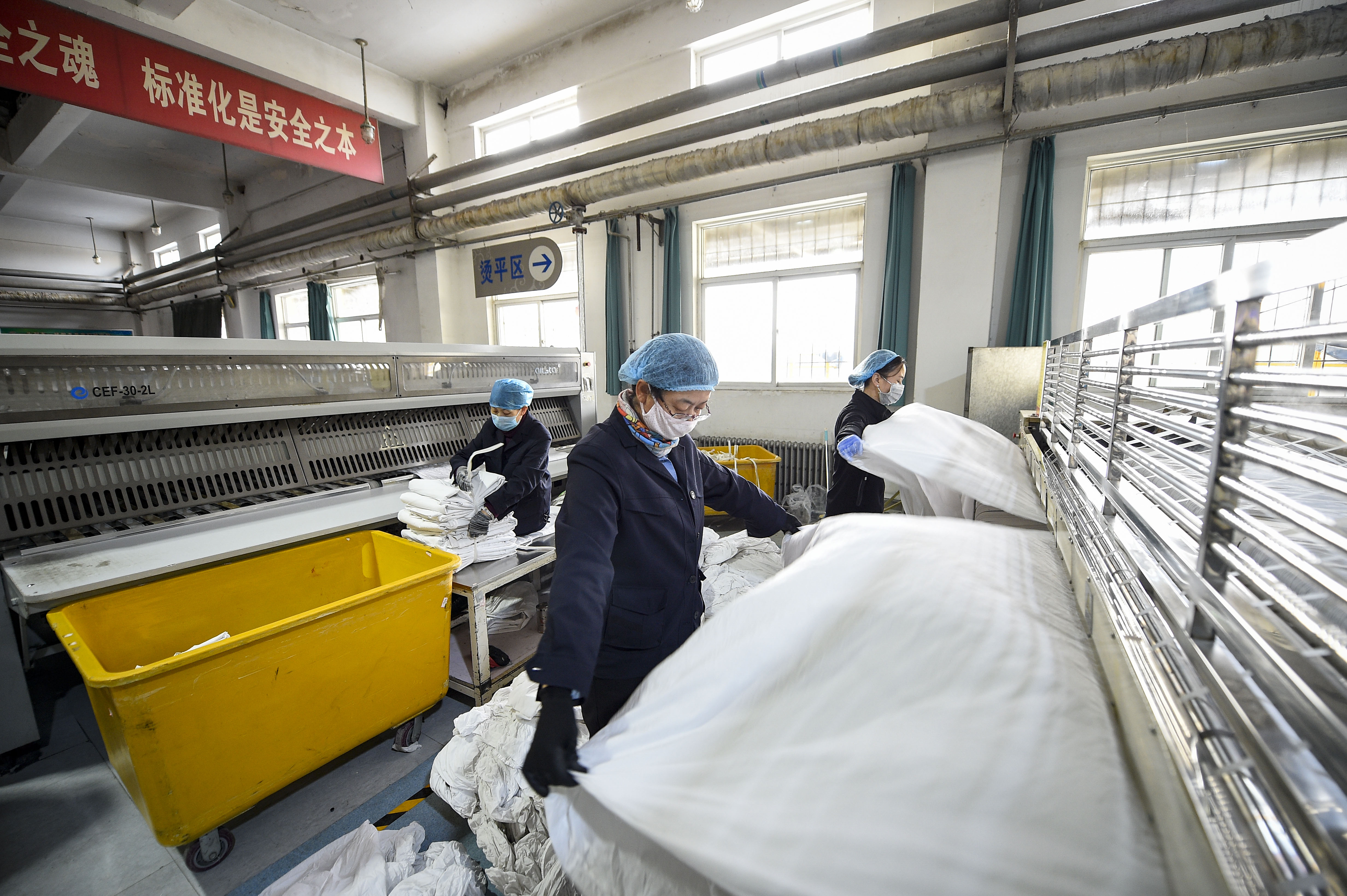 在兰州铁路局银川客运段供应车间洗涤厂的厂房里,工人对洗好的卧具
