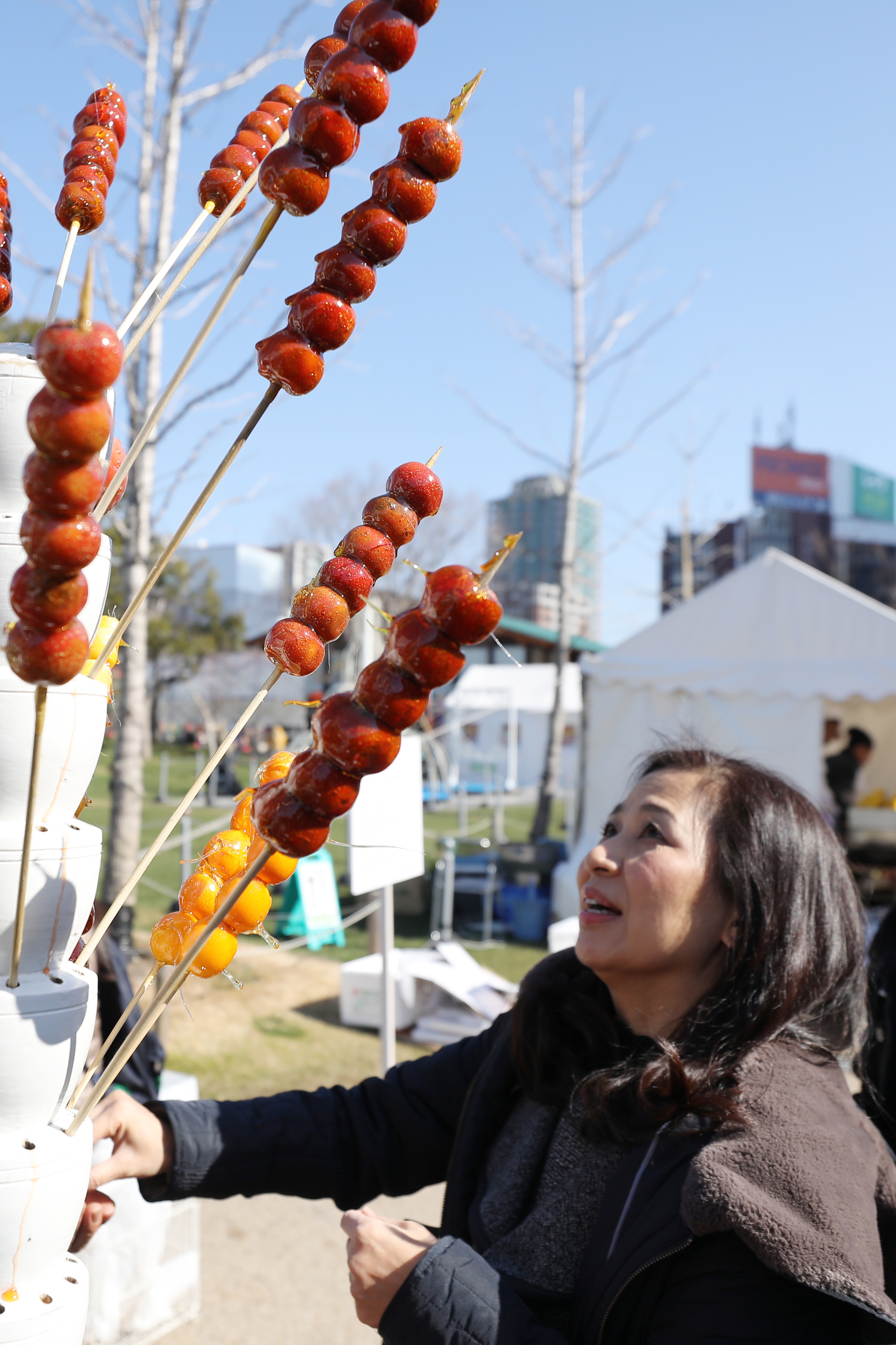 日,在日本大阪天王寺公园,一名游客在"2019大阪春节祭"上购买冰糖葫芦