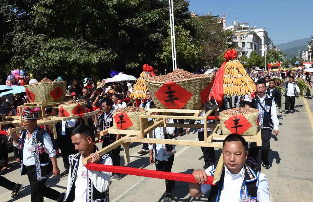 普洱市澜沧拉祜族自治县的少数民族群众在大街上巡游展示丰收的果实.