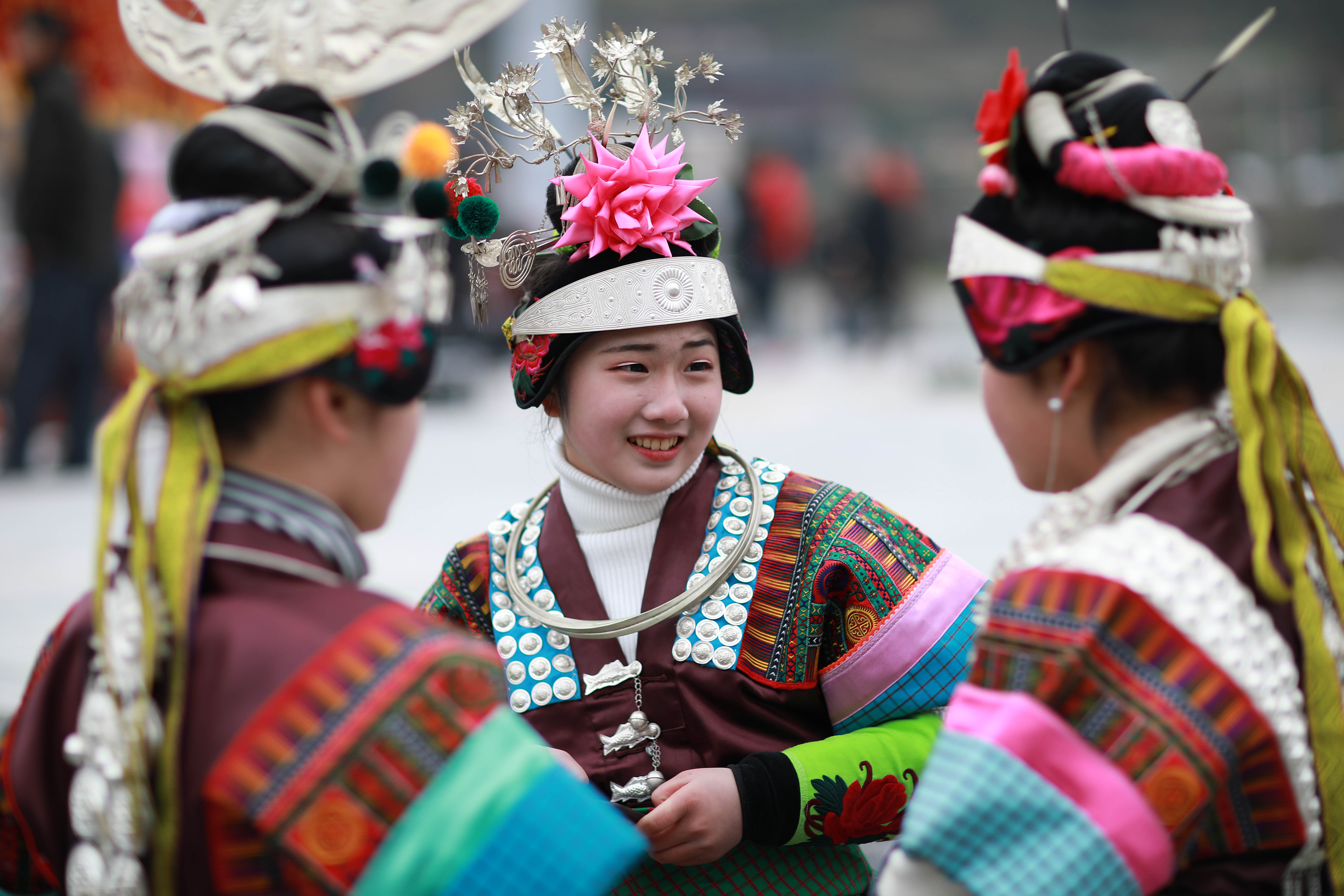 2月8日,在贵州省丹寨县南皋乡九门村迎春芦笙会上,一名女孩在帮同伴戴