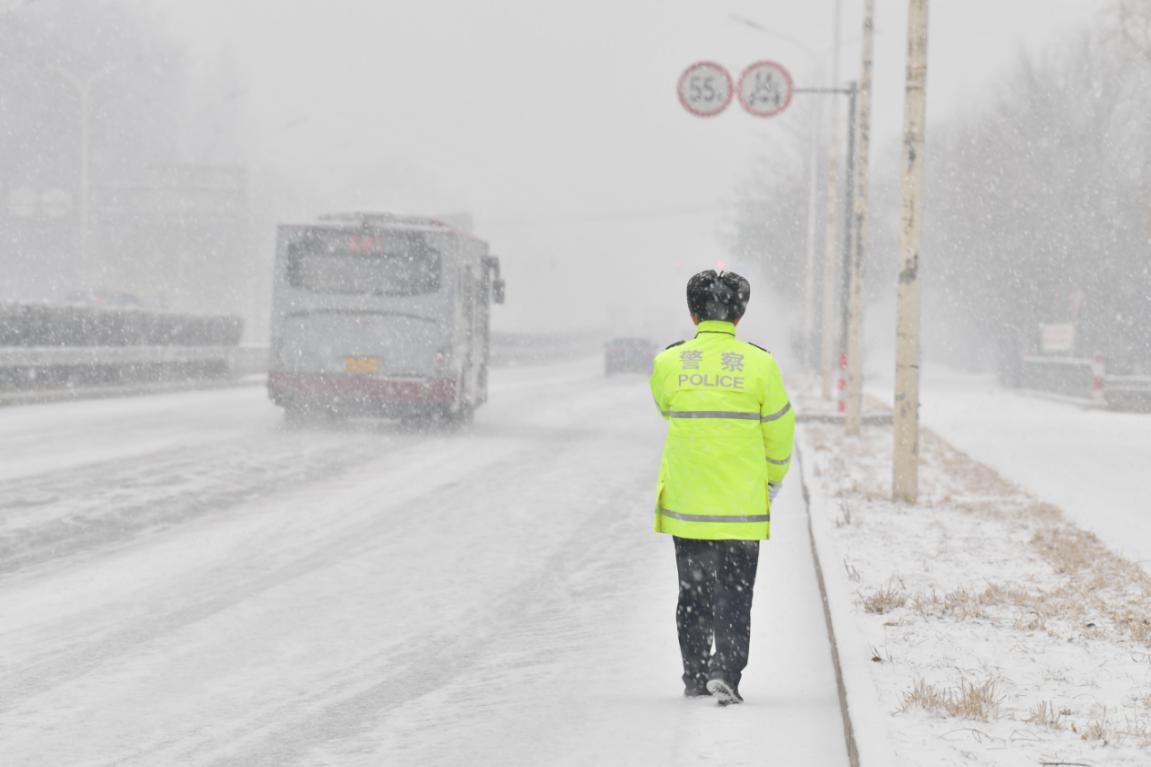 路面值守.上午8时,闫振晴在安四路大柳树路口执勤,指挥过往车辆.