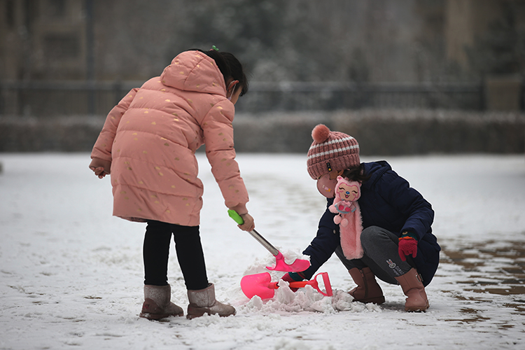 两位小朋友在雪地里玩雪.