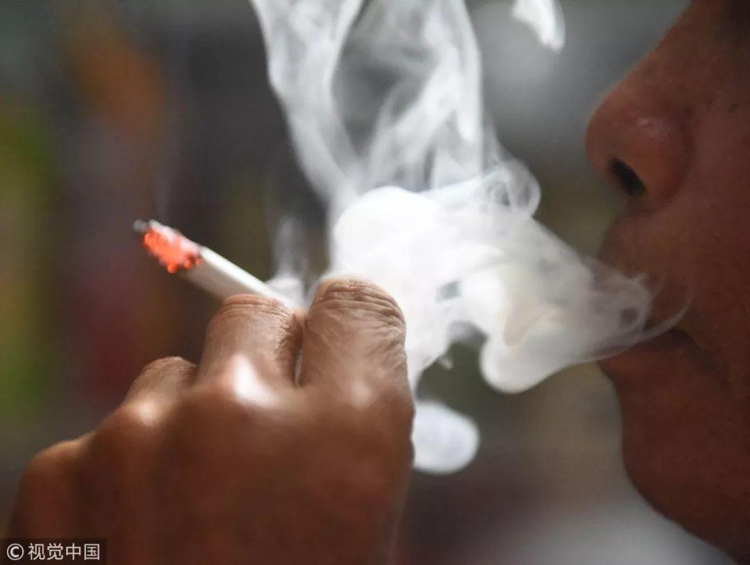 2015年5月8日,海南琼海市一位烟民在吞云吐雾 / 视觉中国2014年