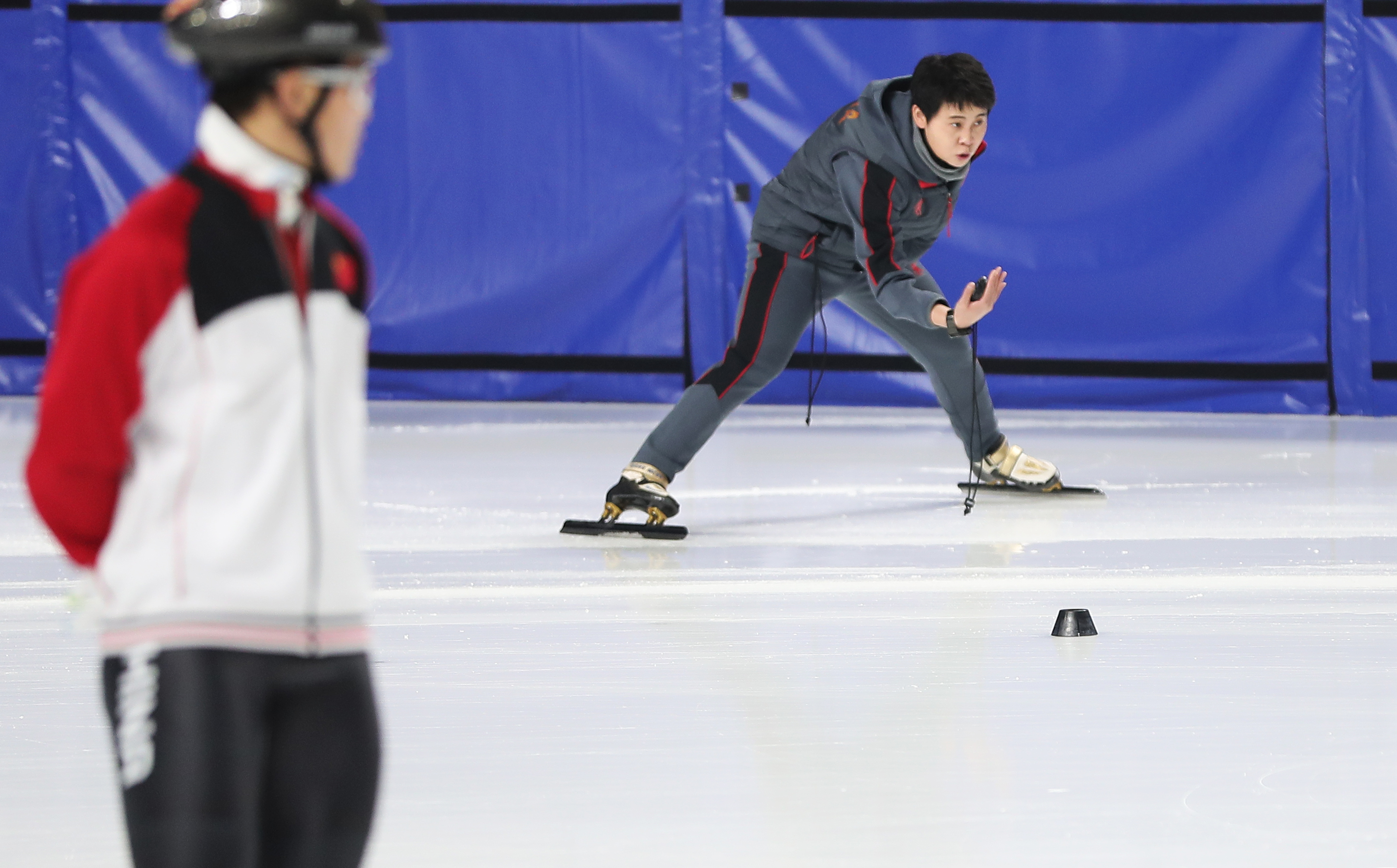 2月28日,大冬会中国短道速滑队主教练王濛(右)在训练中指导队员.