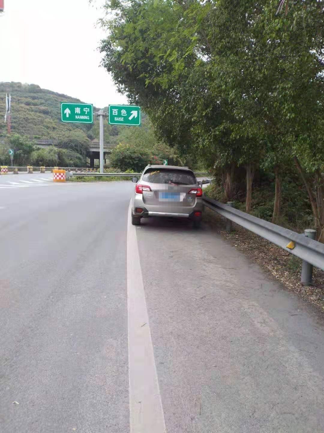 發現田東收費站內廣場匝道轉彎處一輛小型汽車停在應急車道內,既沒