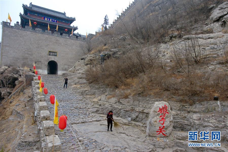 山西省平定縣娘子關鎮娘子關村村民段桂英(前)在清掃景區道路(2月26日