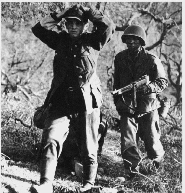 一名德国士兵被黑豹的成员俘虏,拿着汤姆逊机关枪全程押送