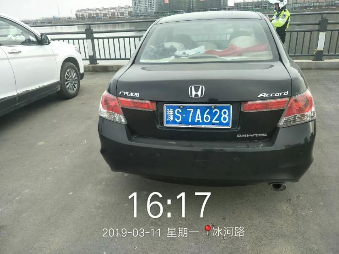 步道上,民警立即对对违法停放在滨河大道机动车道上车牌号为豫s7s798