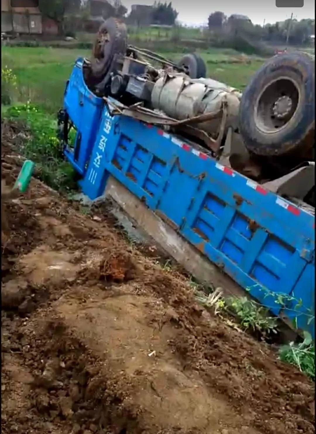 莊家鋪村路段,倒翻在農田的渣土車.