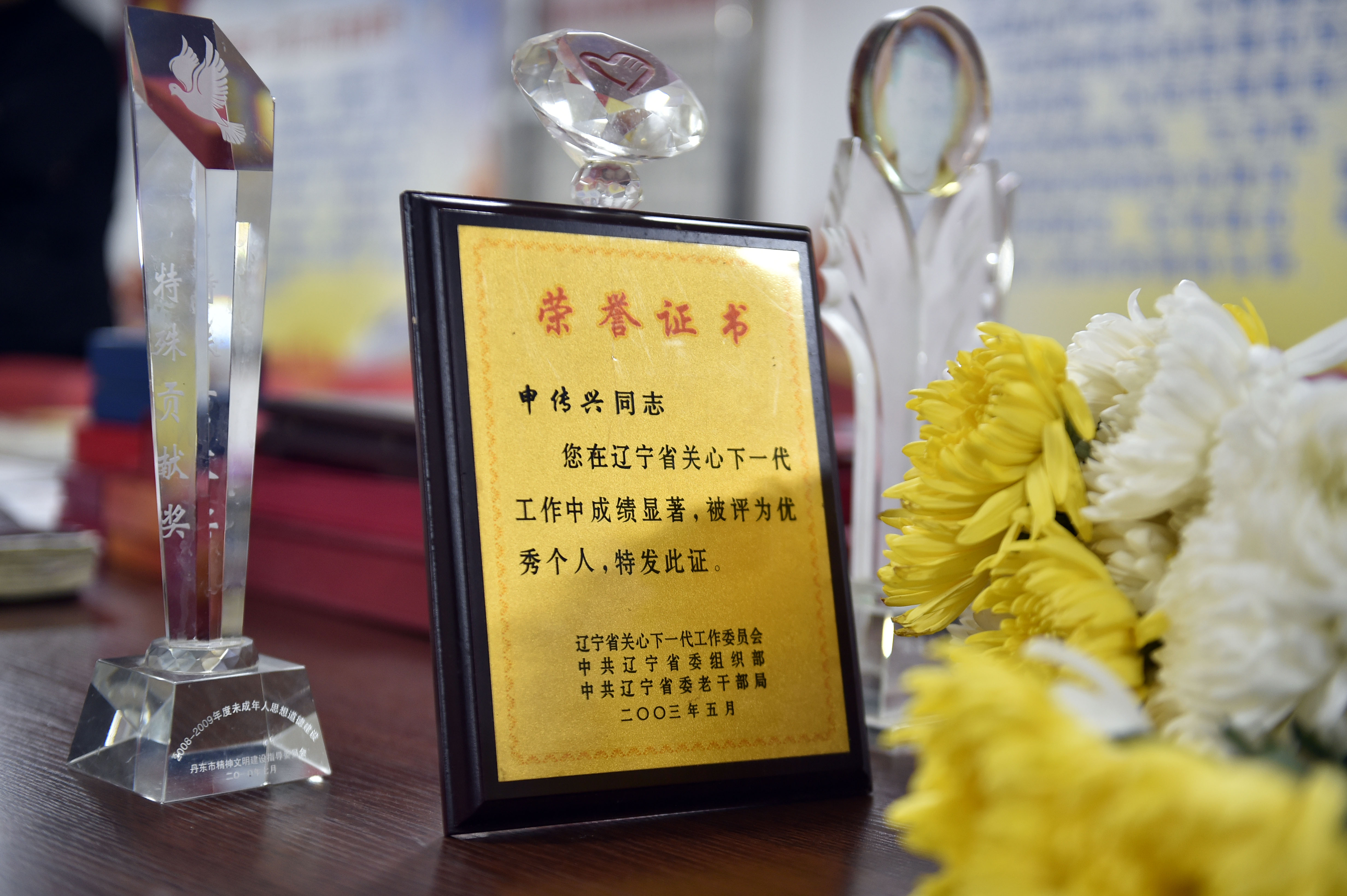 申传兴老人办公桌上摆放着的他生前获得的荣誉证书和奖杯(4月5日摄)