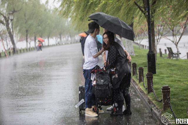 原創突降暴雨,沒帶傘的女生抱成一團防淋溼,成西湖獨特一景