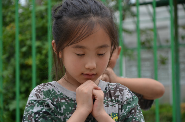 双手合拢好像在祷告着什么,小模样真漂亮啊 夏令营营地里的可爱女孩