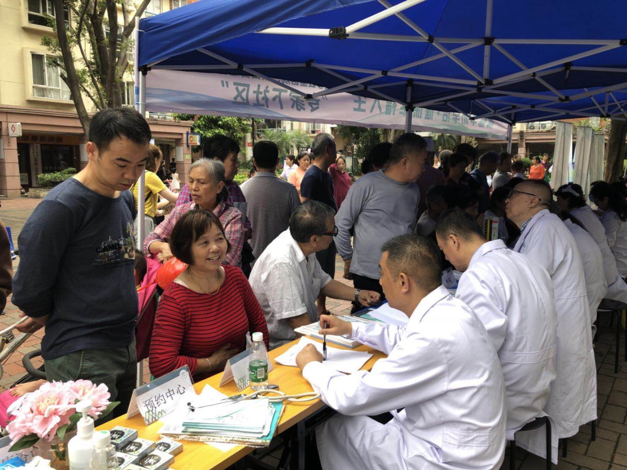 义诊台前吸引了众多过往行人,前来问诊的社区居民排起了长龙,接受专家