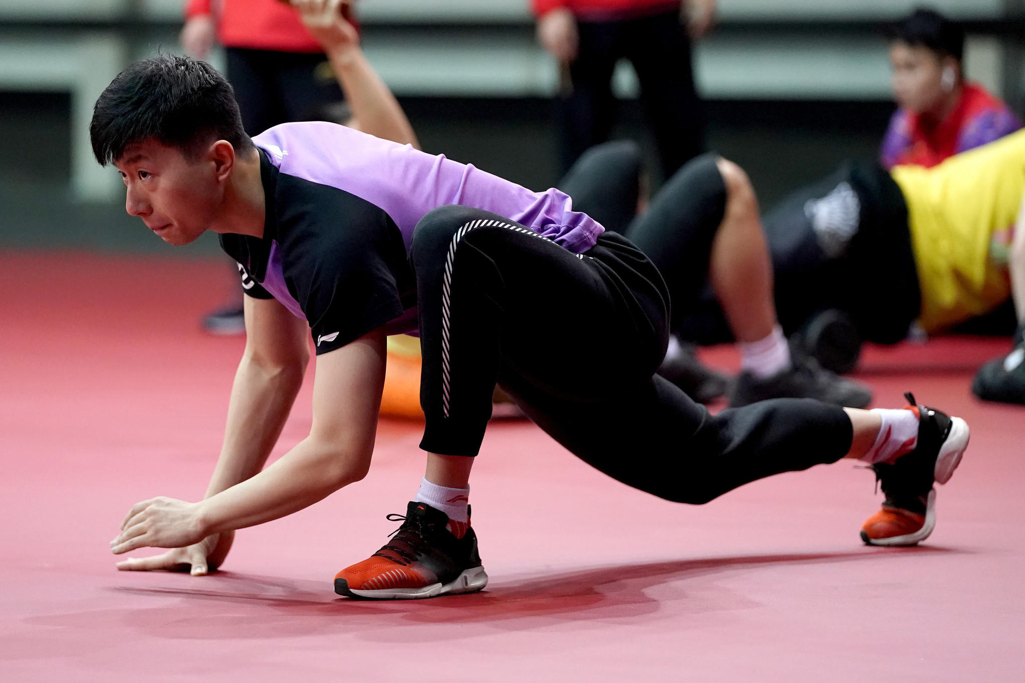 中国男乒队员备战训练世乒赛 马龙压腿表情专注