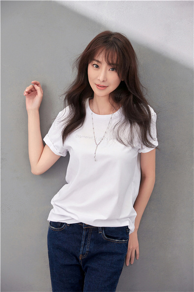 照片中,林静身着简单清爽的白色衬衫搭配深蓝色牛仔裤,颈间佩戴一条