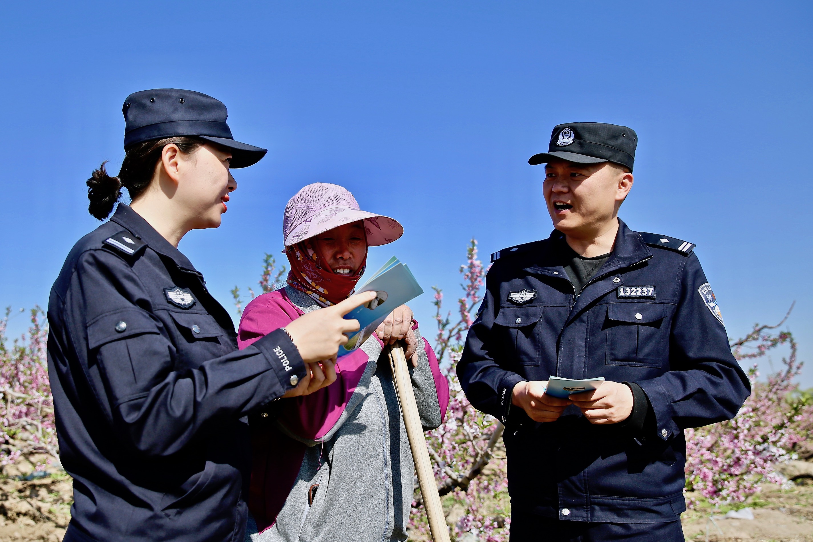 民警向正在桃園勞作的工人進行鐵路愛路護路防傷宣傳