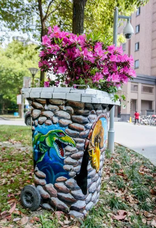 这样废旧垃圾桶就变身为创意花盆了,既实现了废物再利用,又美化了社区