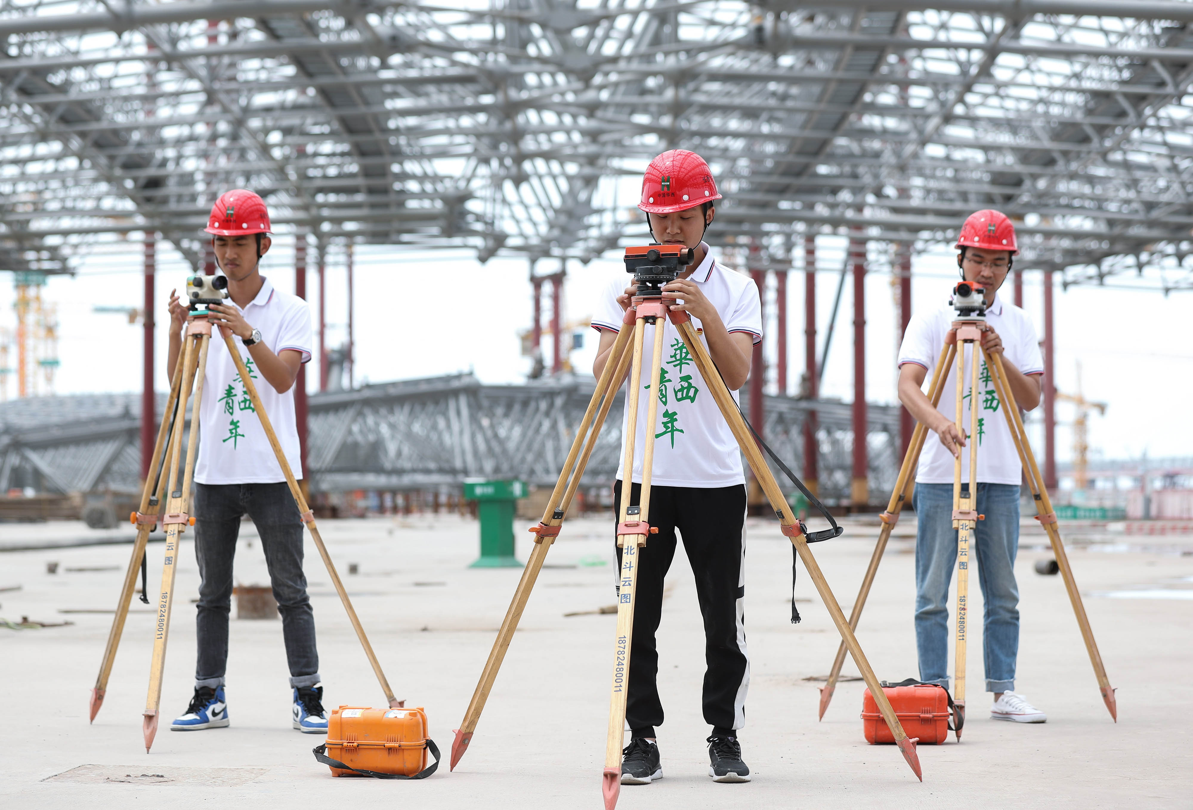 在成都天府国际机场t2航站楼施工现场,青年团员进行水准仪调校技能