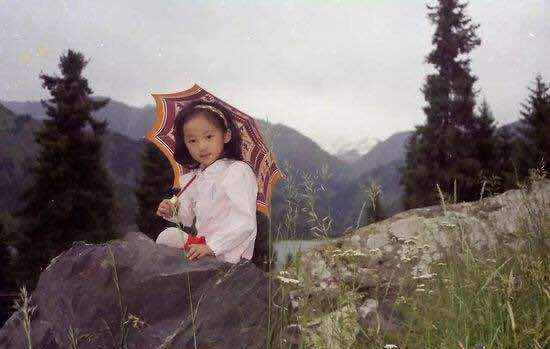 这张照片中的韩雪穿戴红色的小裙子,头上戴着米色的小发箍,打着一把