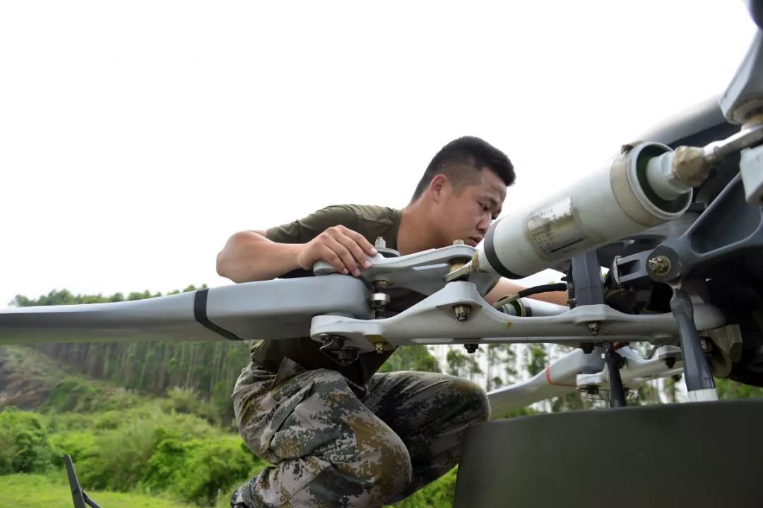 这是某陆航旅驻训场上的一张照片,主人公彭德政一名机务兵, 入伍九年