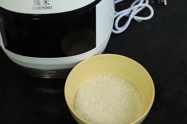 2,将淘洗好的丝苗米倒入电饭煲内,加入适量的清水,清水的用量不要超过