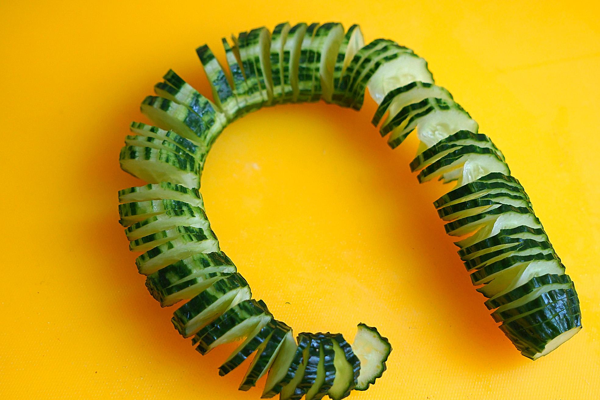 4,然后黄瓜翻过来,再次斜切,切好后拉开来像拉弹簧一样有趣,居然不断