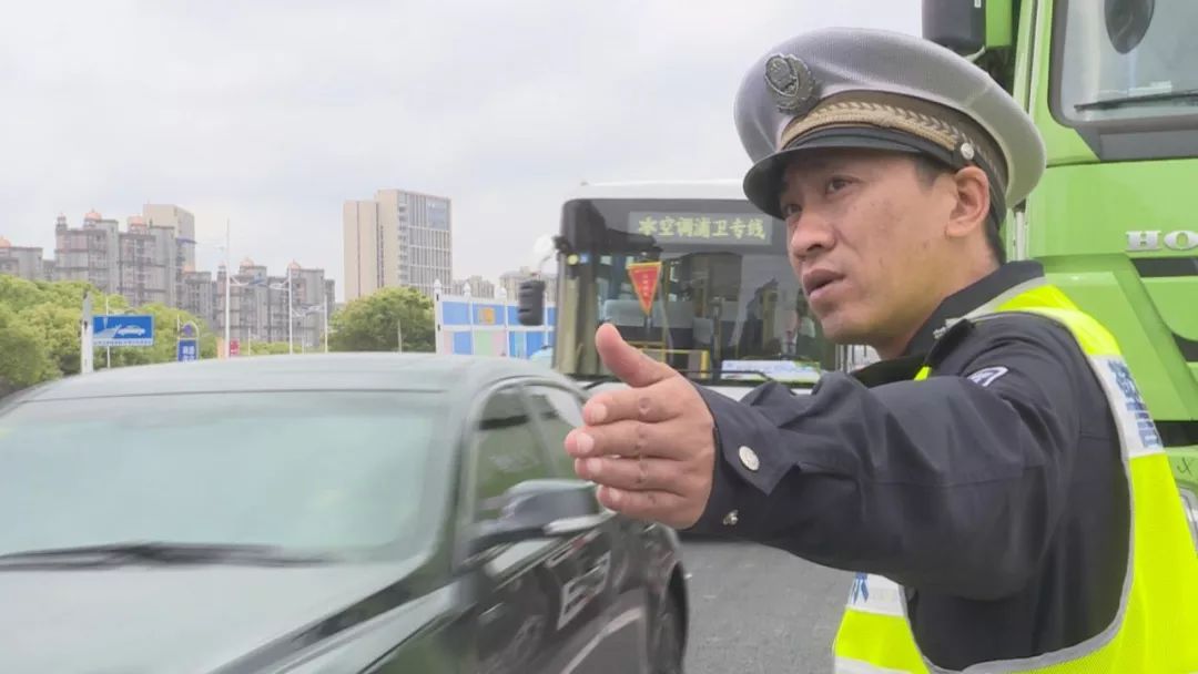 执勤交警在路口指挥交通,同时安排人员通过手控信号灯的方式,调节放行