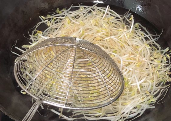 3,锅里下入冷水,加入一勺盐和油煮开,下入豆芽后,关火焯水一分钟捞出